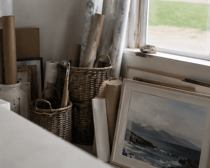 Prints and rolls stored by the window.
